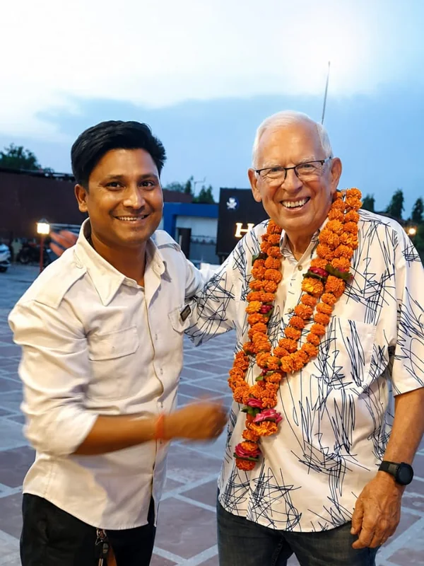 A guest garlanded with marigolds on arrival, beside his driver
